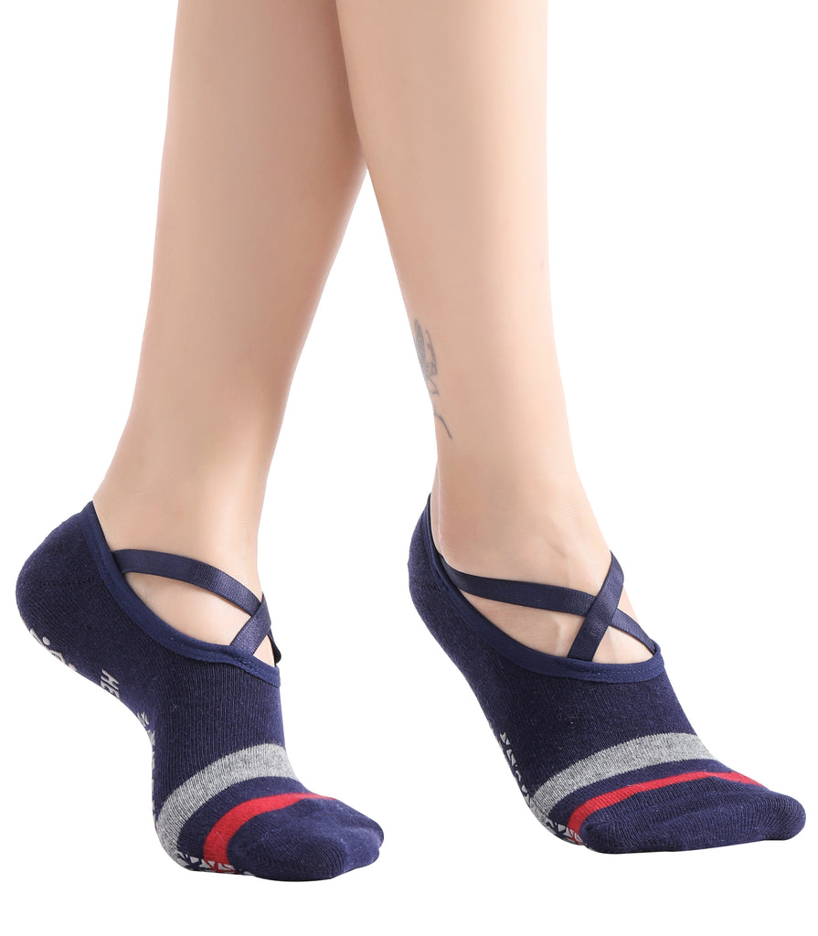 Feet wearing stylish navy ballet socks with crisscross straps, featuring red and gray stripes on the toes.