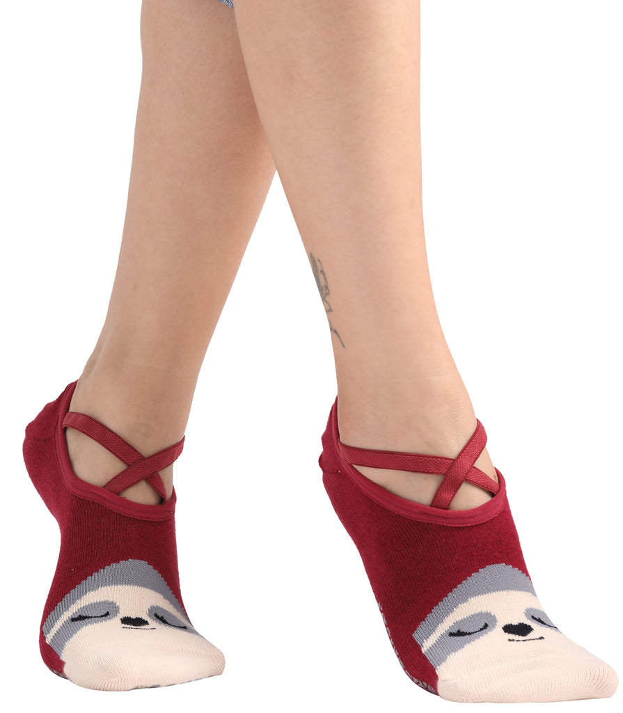Person wearing red ballet-style socks with a cute animal face design on the toes, standing on tiptoes.