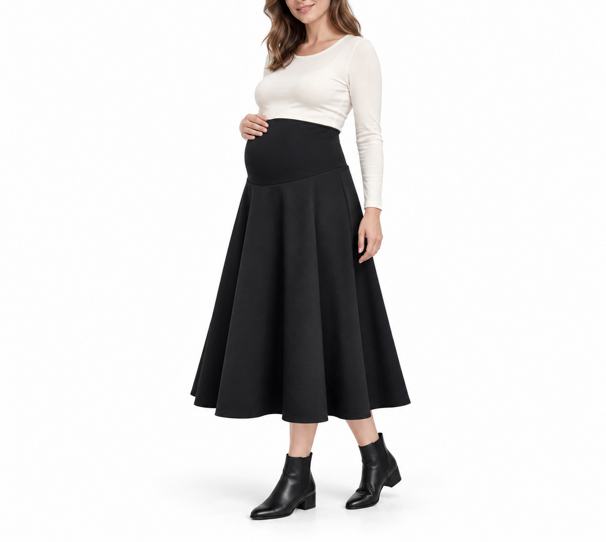 Angled front view of a pregnant model wearing a Black maternity A-line midi skirt with a high waistband, white top, and ankle boots.