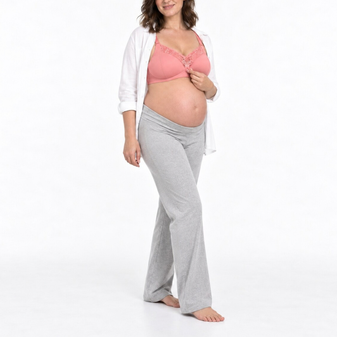 A pregnant woman modeling light gray maternity pants with a matching elastic waistband, styled with a pink bralette and an open white cardigan, standing against a plain white studio background.