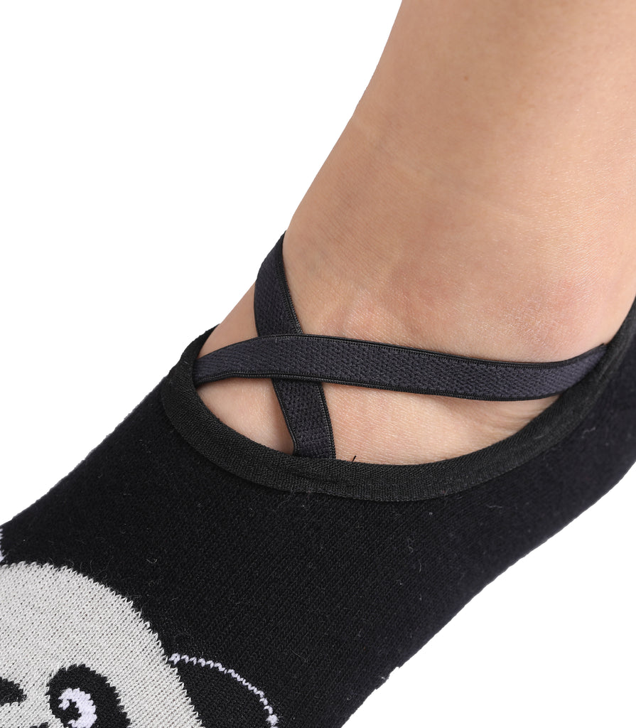 Foot wearing black panda-themed ballet sock with criss-cross elastic straps.