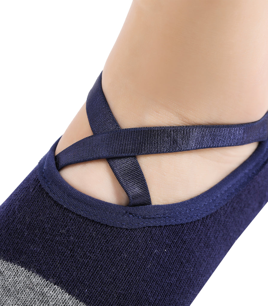 Close-up of a foot wearing a navy blue ballet sock with crisscross elastic straps for a secure fit.