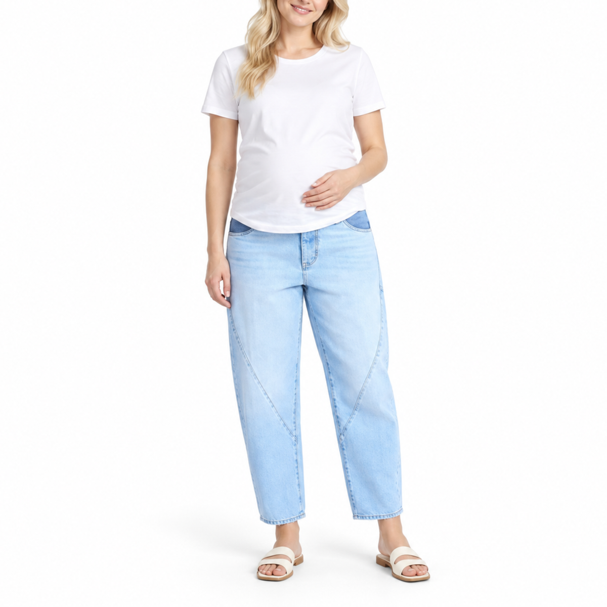 Pregnant woman wearing light blue maternity jeans with a relaxed curved-leg silhouette and cropped ankle length.